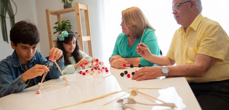 Grandparents and grandchildren engage in a creative building activity indoors.