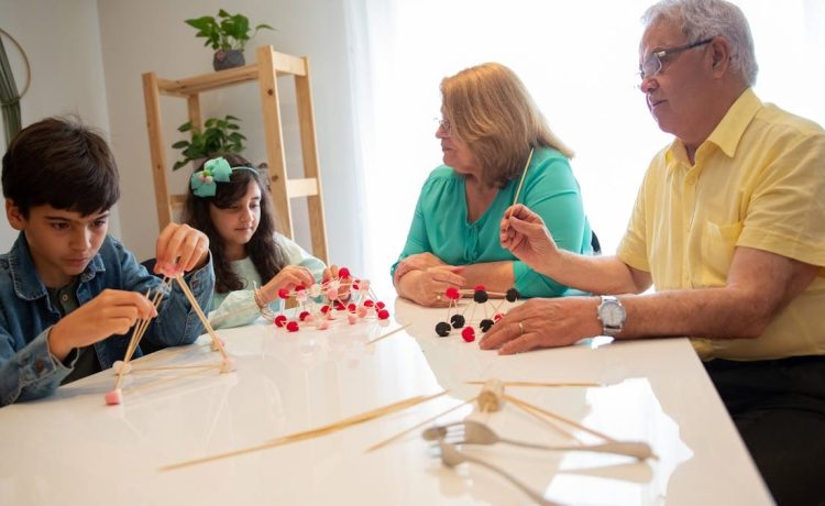 Grandparents and grandchildren engage in a creative building activity indoors.