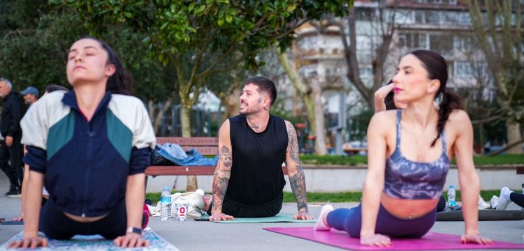 Group practicing yoga outdoors on mats in İstanbul park, embracing wellness and tranquility.